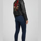 Scarlett Stitch black faux leather moto jacket with embroidered red and pink roses on the back. Classic biker style with zippered cuffs.