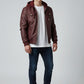 Scarlett Stitch burgundy faux leather hooded bomber jacket with zip front and chest pockets. Model wears white t-shirt and jeans.