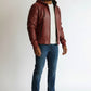 Scarlett Stitch Men's burgundy hooded leather bomber jacket with quilted shoulders and zippered pockets.