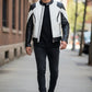 Scarlett Stitch men's black and white leather motorcycle jacket with quilted shoulders worn by a model on a city street