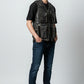 Man wearing a Scarlett Stitch distressed leather utility vest with multiple pockets over a black t-shirt and jeans.