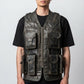 Man wearing a Scarlett Stitch distressed leather utility vest with multiple pockets and a front zipper closure.
