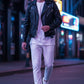 Scarlett Stitch black faux leather biker jacket with asymmetrical zipper, worn by a man in a city street at night.