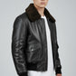 Scarlett Stitch Men's black faux leather bomber jacket with dark brown shearling collar, ribbed cuffs and hem, zip front, and flap pockets.