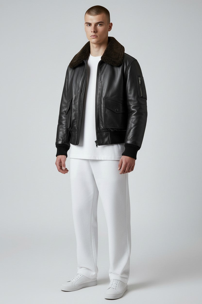 Scarlett Stitch Men's black faux leather bomber jacket with dark brown shearling collar, zip front, and chest pockets.