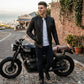 Scarlett Stitch men's black leather motorcycle jacket with quilted shoulder panels and mandarin collar on a model.