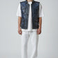 Model wearing a Scarlett Stitch distressed blue leather utility vest with snap pockets over a white t-shirt.