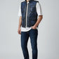 Model wearing a Scarlett Stitch distressed blue leather utility vest with snap-button pockets and a stand-up collar.
