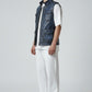 Model wearing a Scarlett Stitch distressed blue leather utility vest with front pockets over a white t-shirt and pants.