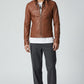 Scarlett Stitch men's brown faux leather jacket with stand collar, zip front, and tailored fit on a male model.