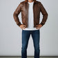 Scarlett Stitch Men's brown leather bomber jacket with ribbed collar, cuffs, and hem. Features dual chest pockets and side pockets.