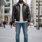 Scarlett Stitch Men's dark brown faux leather bomber jacket with shearling collar, zip-front, flap pockets, and ribbed cuffs.