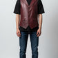 Scarlett Stitch men's burgundy leather vest with lapel collar, button front, flap pockets, and belt detail. Tailored fit.