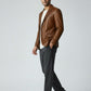Man wearing a Scarlett Stitch cognac brown leather blazer with notch lapels, white tee, and grey trousers.