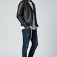 Man wearing a black Scarlett Stitch leather biker jacket with silver hardware, white t-shirt, and dark blue jeans.