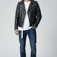 Model wearing a Scarlett Stitch black leather biker jacket with silver hardware, white t-shirt, and blue jeans.