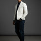 Man wearing a Scarlett Stitch off-white leather blazer with a dark shirt, jeans, and white sneakers in studio.