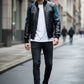Scarlett Stitch men's black leather bomber jacket with blue accents on sleeves and shoulders, ribbed cuffs and hem.