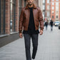 Scarlett Stitch Men's genuine leather bomber jacket in rich brown with ribbed collar, cuffs, and hem. Features zip front, flap pockets, and epaulets.