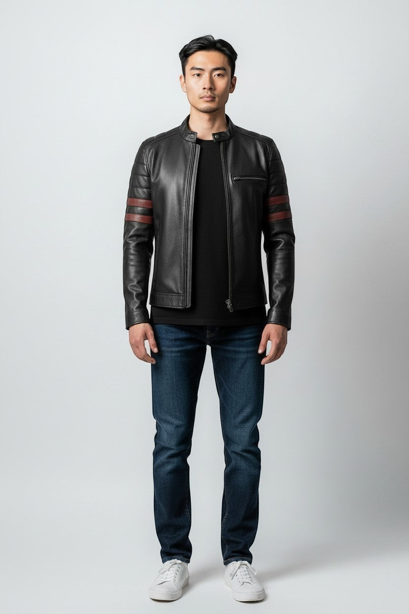 A man wearing a Scarlett Stitch black leather racer jacket with red sleeve stripes, dark jeans, and white sneakers.