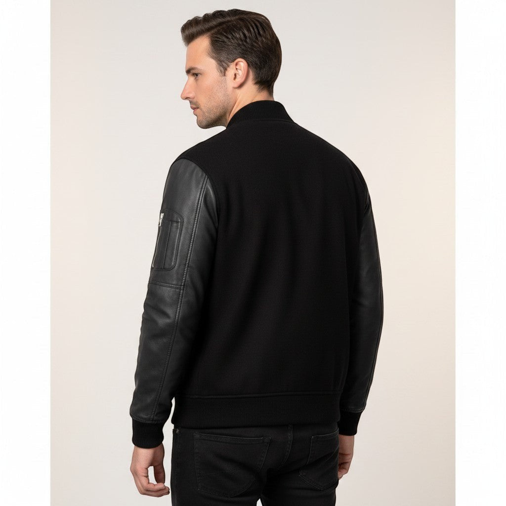 Scarlett Stitch Men's black bomber jacket with genuine leather sleeves, ribbed collar, cuffs, and hem, and zippered sleeve pocket.