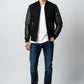 Scarlett Stitch Men's black bomber jacket with genuine leather sleeves, ribbed collar, cuffs, and hem. Features zippered pockets.