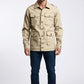 Scarlett Stitch Men's beige cotton blend safari utility jacket with multiple flap pockets and epaulets.