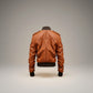 Scarlett Stitch Men's tan genuine leather bomber jacket with ribbed collar, cuffs, hem, and epaulet details.
