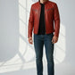Model wearing a Scarlett Stitch red leather biker jacket with quilted shoulders and metal zippers over a black shirt.