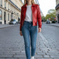 Scarlett Stitch women's red leather bomber jacket with folded collar, zip-front, and ribbed cuffs. Model wears with jeans.