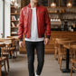 Scarlett Stitch men's red leather bomber jacket with ribbed collar and cuffs, zippered chest pockets, and button waist pockets.