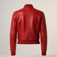 Scarlett Stitch red leather bomber jacket with ribbed collar, cuffs, and hem. Features zippered front and sleeve pockets.