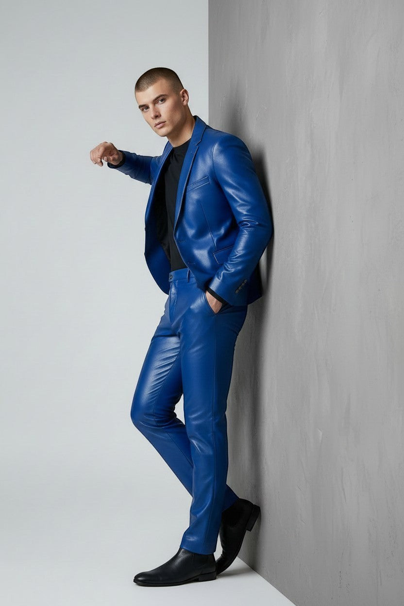Man wearing a royal blue Scarlett Stitch faux leather suit jacket and matching trousers against a grey wall.