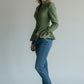 Scarlett Stitch sage green tailored peplum jacket with button detail and bow cuffs, worn by a model with jeans.