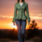 Scarlett Stitch sage green tailored peplum jacket with antique brass buttons and bow cuff detail, worn by a woman in jeans.