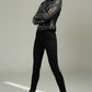 Model wearing a black Scarlett Stitch leather biker jacket with silver stud embellishments and a belted waist.