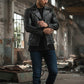 Scarlett Stitch black leather motorcycle jacket for men with silver studs, lapel collar, zip closure, and zippered cuffs.