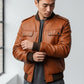 Scarlett Stitch men's tan faux leather bomber jacket with ribbed collar, cuffs, and hem. Features snap chest pockets.
