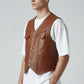 Model wearing a tan Scarlett Stitch leather button-front vest with utility pockets over a white t-shirt.