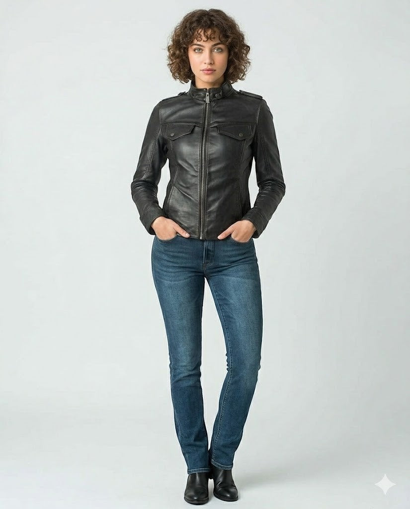 Scarlett Stitch Women's black faux leather moto jacket with zippered pockets and snap-button collar. Model wears jeans and boots.