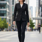 Scarlett Stitch women's black tailored blazer with notched lapel and three-button closure, paired with black pants and boots.