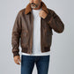 Scarlett Stitch men's distressed brown faux leather bomber jacket with sherpa collar, ribbed cuffs and hem, and dual chest pockets.