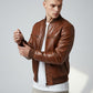 Scarlett Stitch men's brown leather bomber jacket with ribbed collar, cuffs, and hem. Features zippered pockets.