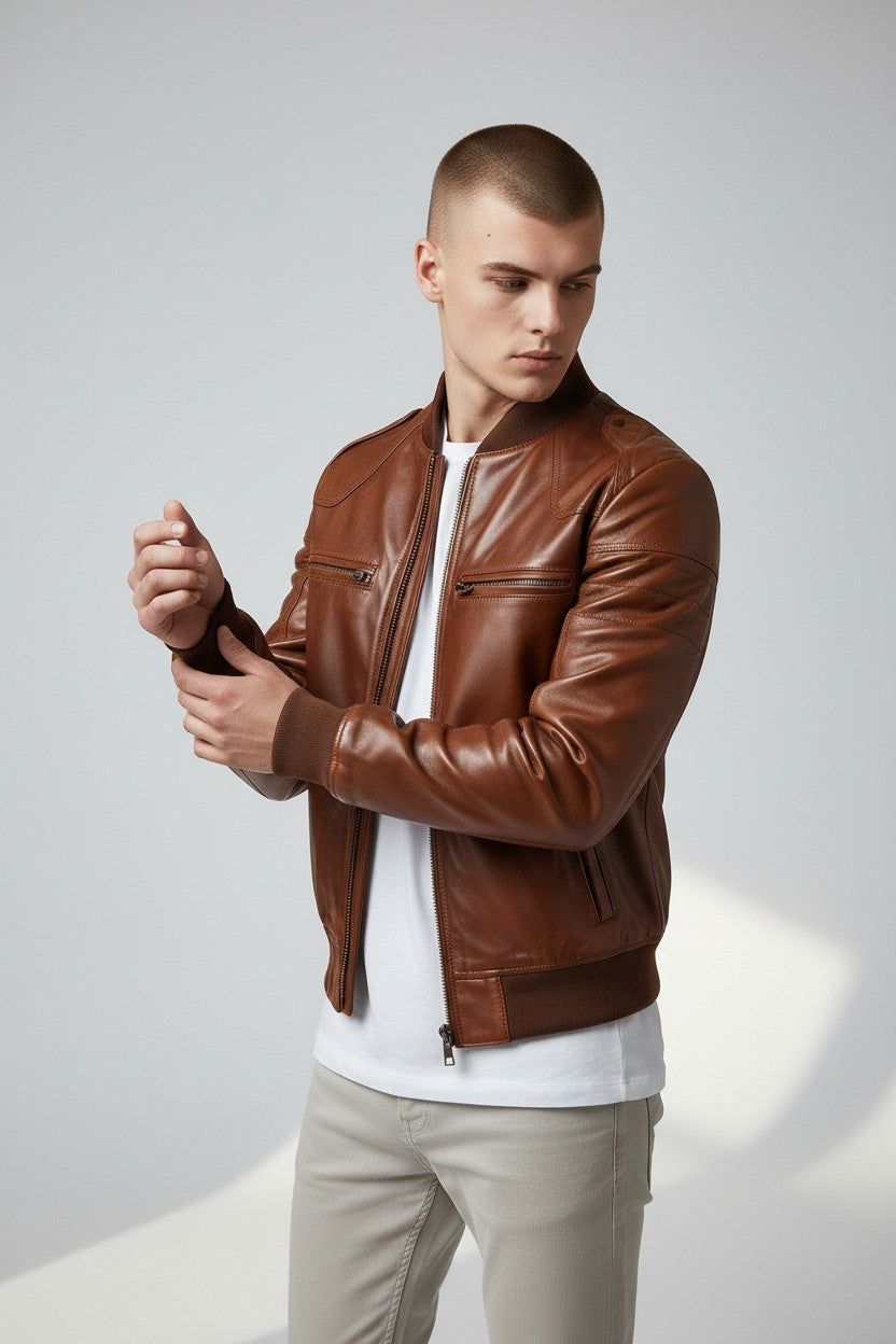 Scarlett Stitch men's brown leather bomber jacket with ribbed collar, cuffs, and hem. Features zippered pockets.