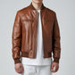Scarlett Stitch men's brown leather bomber jacket with ribbed collar, cuffs, and hem. Features zippered pockets and a sleek silhouette.