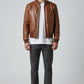 Scarlett Stitch men's brown leather bomber jacket with ribbed collar, cuffs, and hem. Zip-front closure and side pockets.