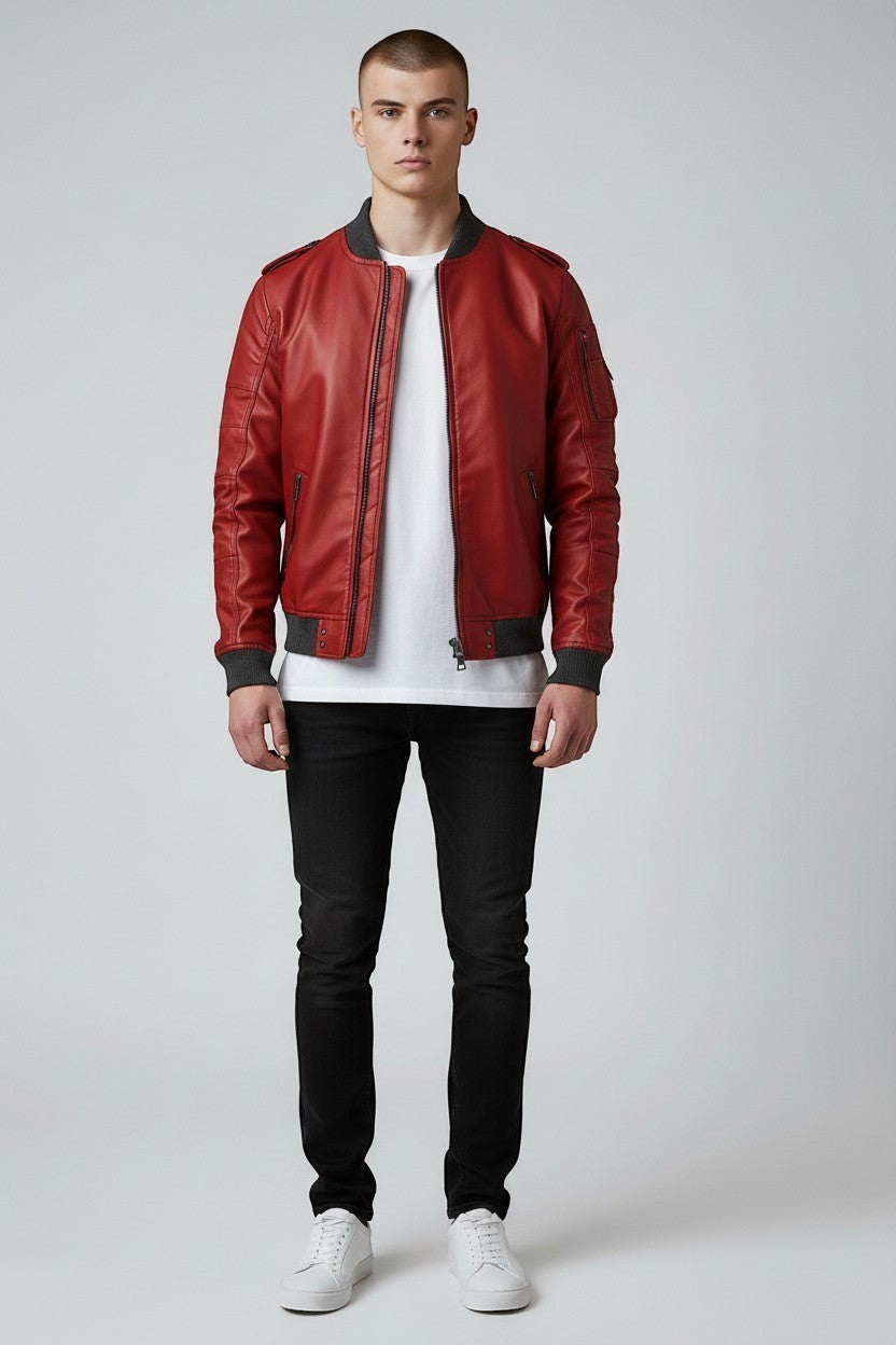 Scarlett Stitch men's red faux leather bomber jacket with ribbed cuffs and grey collar. Model wears white t-shirt and black jeans.