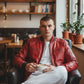 Scarlett Stitch men's red leather bomber jacket with ribbed collar and cuffs, zippered pockets, and satin lining.